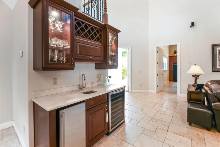 Bar with ice maker, wine/beverage  refrigerator and sink.