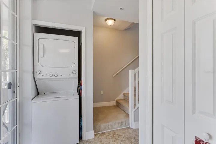 Laundry closet and the stairs that lead to the primary bedroom and guest bedroom.