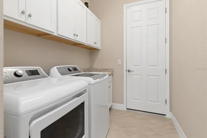 Laundry room with cupboards above.