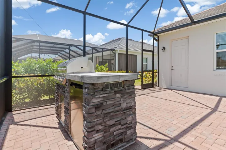 Outdoor kitchen with grill and fridge.