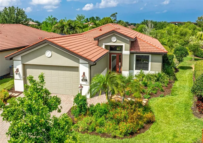 Beautiful paver driveway and expanded walkway with new native Florida tropical landscaping leading to a covered front porch.