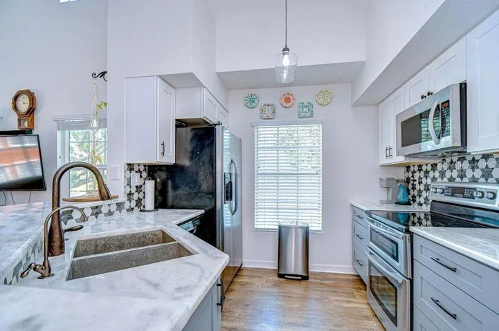 Upgraded Kitchen with Double oven, custom tile backsplash, stainless Microwave. Upgraded new cabinets.