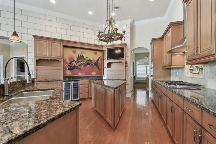 Two appliance garages, a wine refrigerator, an island and a gorgeous piece or art over the wine refrigerator.