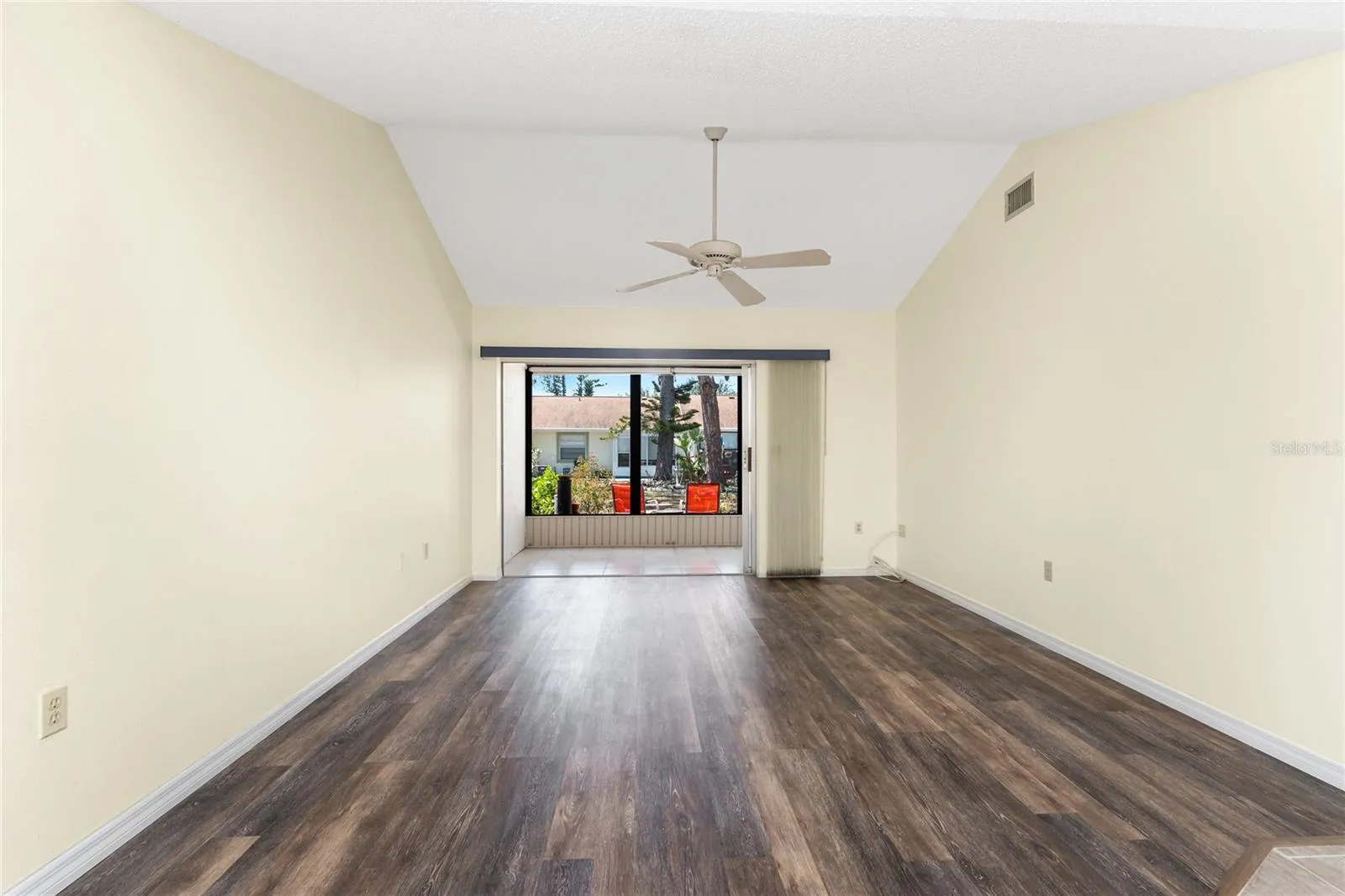 Main living area has a cathedral ceiling and ceiling fan, plus sliding glass doors to the lanai.