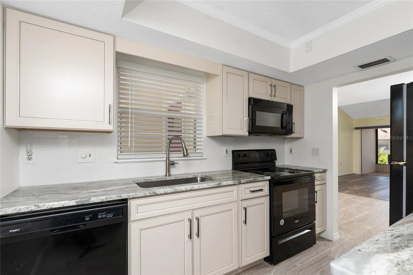 Black appliances make for a more dramatic look and tie in the color of the granite.