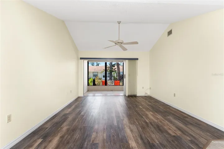 Main living area has a cathedral ceiling and ceiling fan, plus sliding glass doors to the lanai.