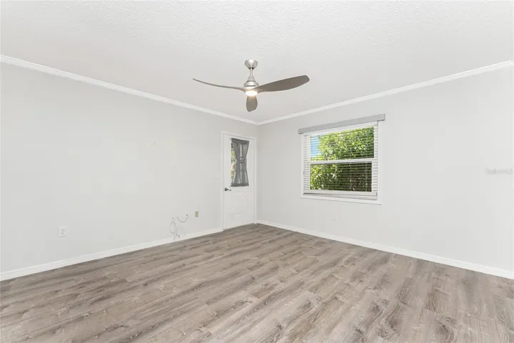 Primary bedroom has laminate flooring and door to the Lanai