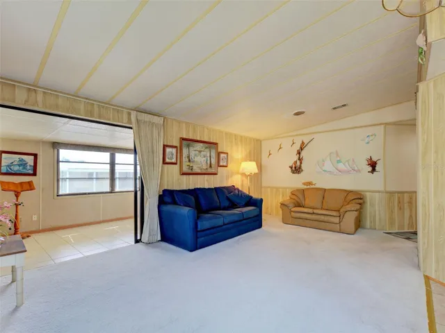 LIVING ROOM WITH VAULTED CEILING AND LEADS OUT TO LARGE FLORIDA ROOM.