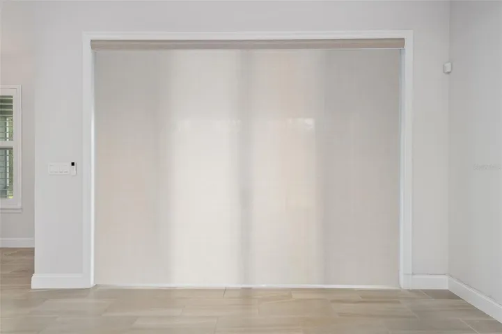 Motorized rool down shutter in living room over slider