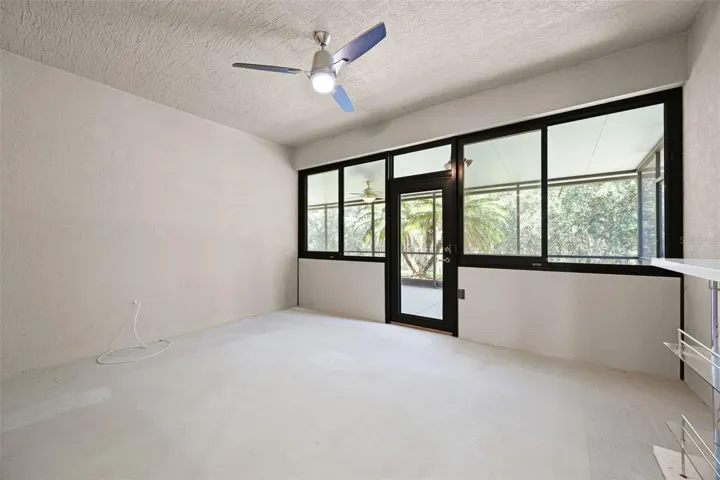 enclosed patio with windows and door leading to screened in porch