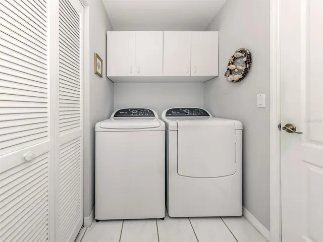 The laundry room has a built-in closet and cabinets.