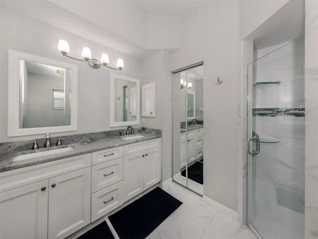 The renovated primary bedroom ensuite is complete with dual sinks, a walk-in shower and mirrored linen closet.