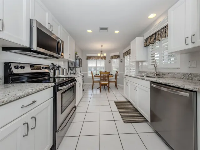 The kitchen opens up to the breakfast nook surrounded by windows with plantation shutters.