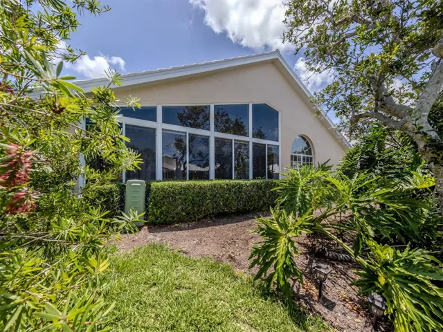 A view of the back of the home with mature landscaping.