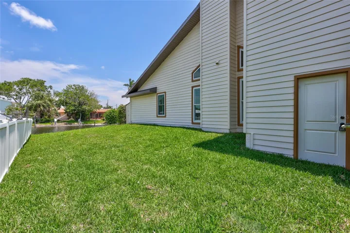 The left side yard of the home has a side door to the garage.