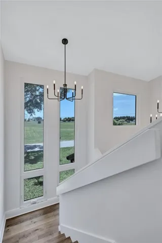 The two-story entryway, featuring stairs, leads to the Primary Suite.
