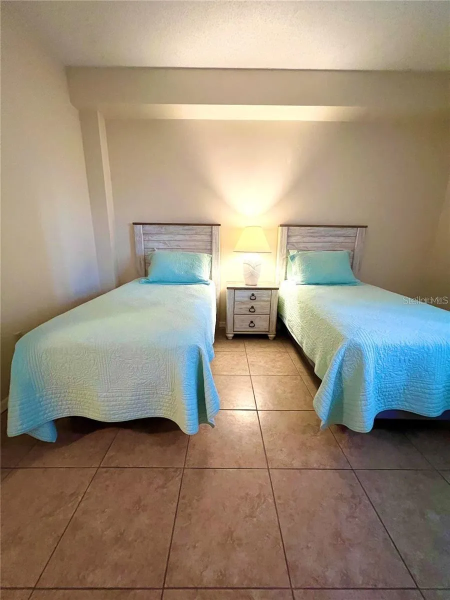 Second bedroom with twin beds and large window