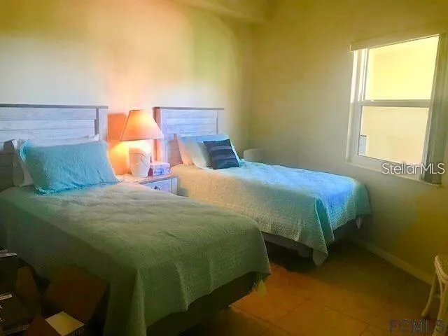 Second bedroom with twin beds and large window