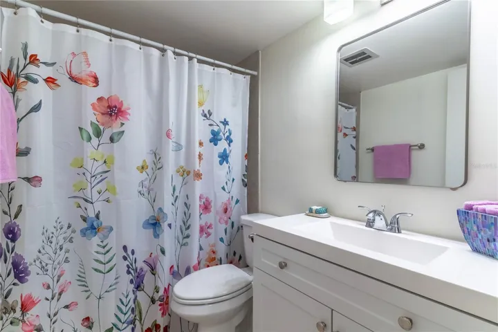 New vanity, toilet, light fixture and mirror in the bathroom.