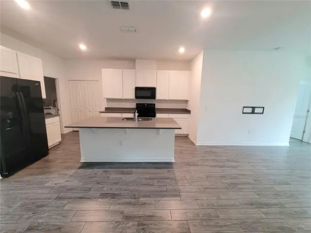 White 42" cabinetry, quartz countertops,  spacious pantry, left door leading to the laundry room and garage access