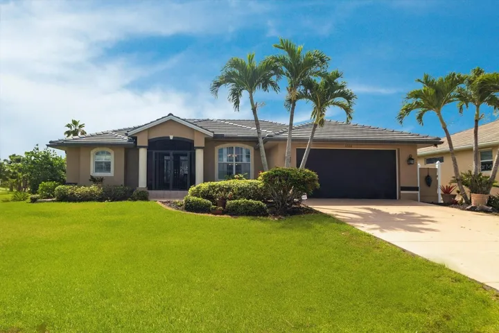 Beautifully maintained home with lush, professionally landscaped lawn, welcoming entry, and spacious garage.