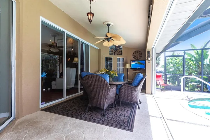 Inviting covered lanai with dining area, ceiling fan, and seamless connection to interior living spaces.