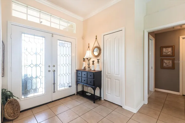 Light-filled foyer with elegant glass doors and spacious tiled entry.