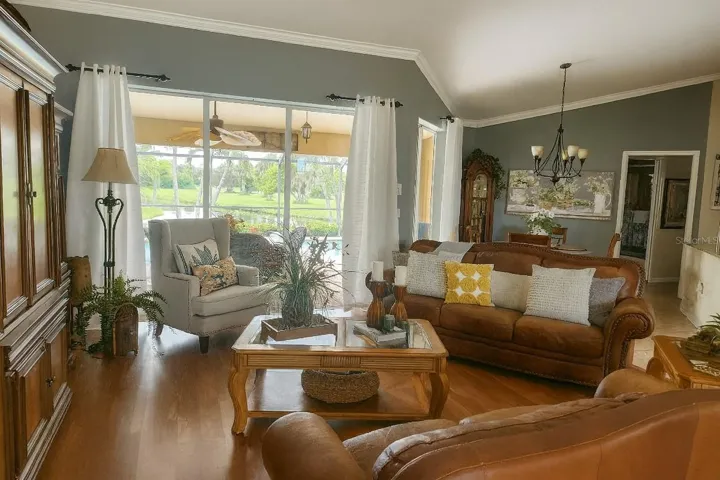 Elegant living area featuring vaulted ceilings, crown molding, and rich wood flooring.