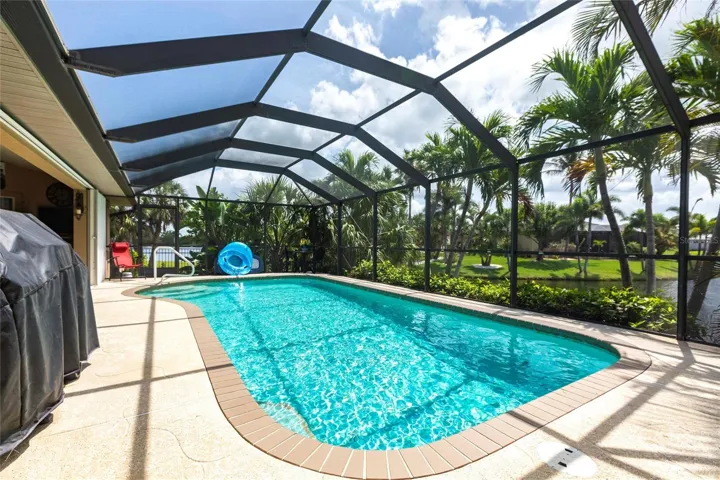 Private screened pool overlooking tranquil water and lush landscaping.