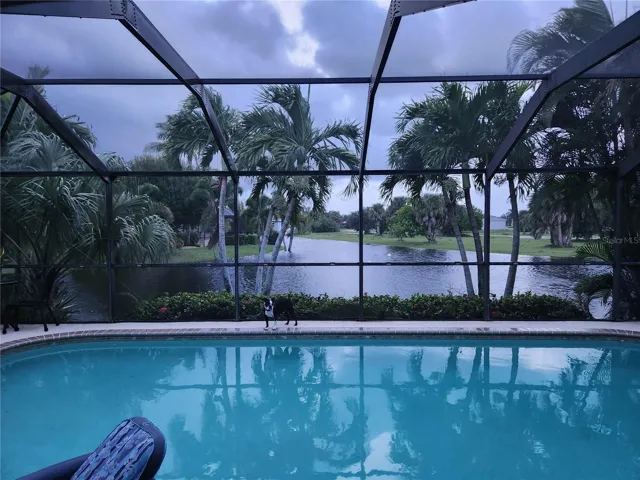 Evening shot of your private screened pool overlooking tranquil water and lush landscaping