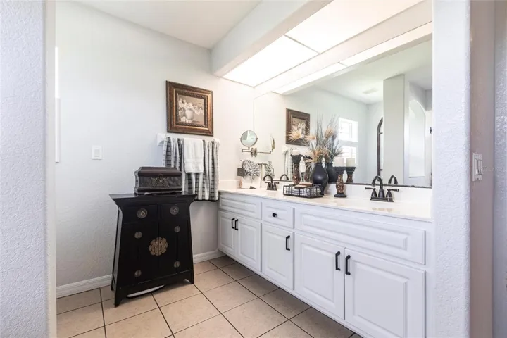 Well-appointed primary bathroom with dual vanities, ample cabinetry, and oversized mirror.