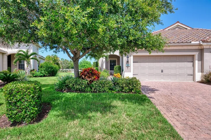 Mature, lush and tropical Florida landscaping with paver drive way and tile roof.