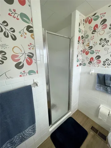 This bath has been remodeled, nice wall paper as well.