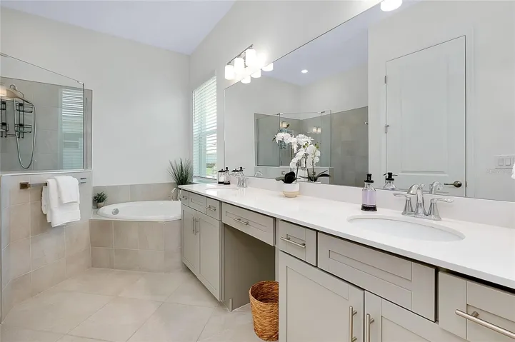 Primary bath with double sinks, bath tub and walk-in shower.