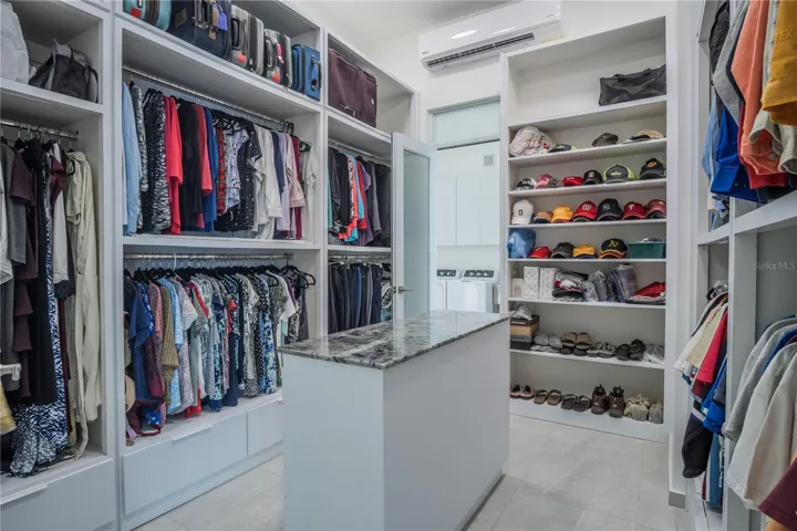Large walk-in closet with custom built-ins and direct access to laundry.