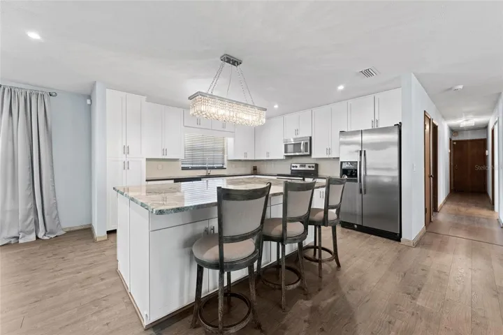 Resort-Style Backyard offers a pool, multiple seating areas, and a covered outdoor kitchen!