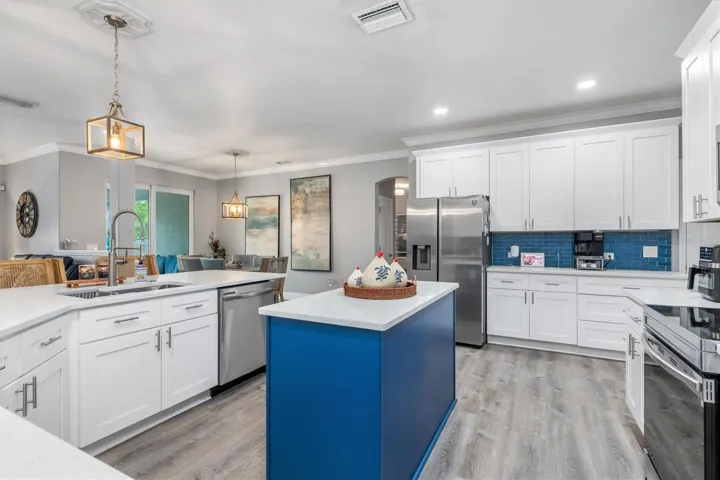 Upgraded kitchen with white shaker cabinets and accent color on island.