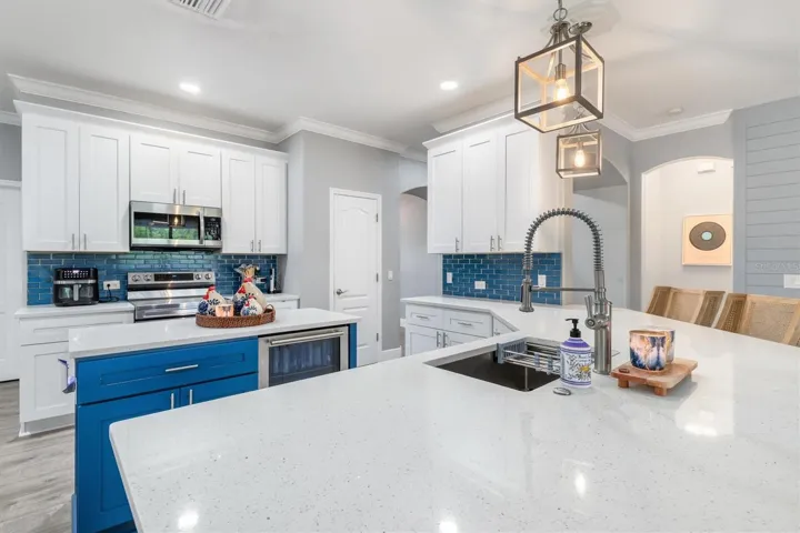 Chef's kitchen with range, microwave and subway tile backsplash.
