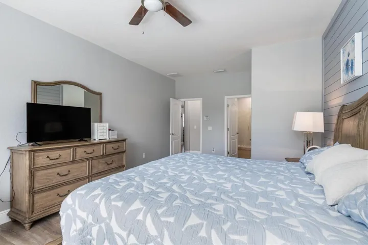 Spacious and light bedroom with fan and luxury vinly flooring.
