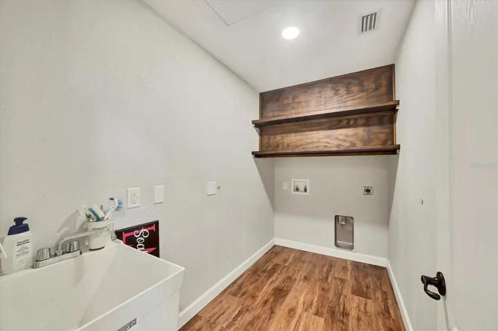 laundry room with utility sink between bedroom 2 and 4
