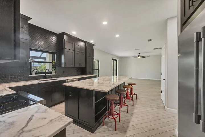 bar stools remain with home, note large commercial fridge (similar to sub zero style)