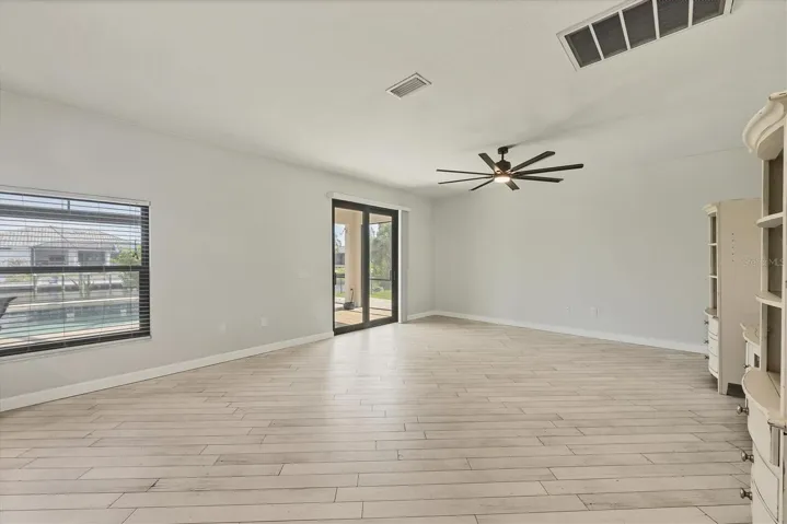 family room flows easily from kitchen, great for entertaining or large groups, sliders lead out to lanai and pool