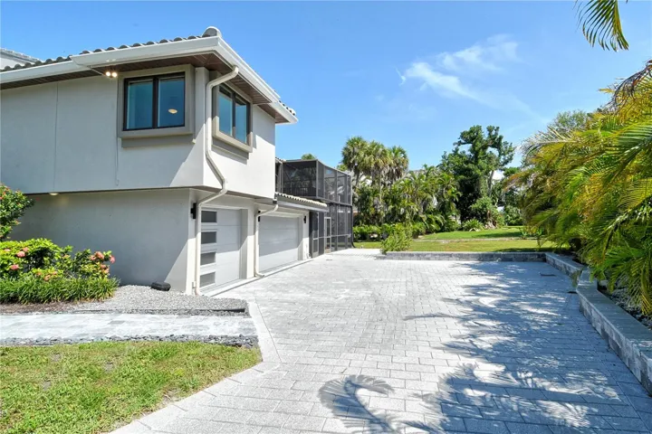 Home features a spacious three car garage and a stylish driveway, combining practicality with polished curb appeal.
