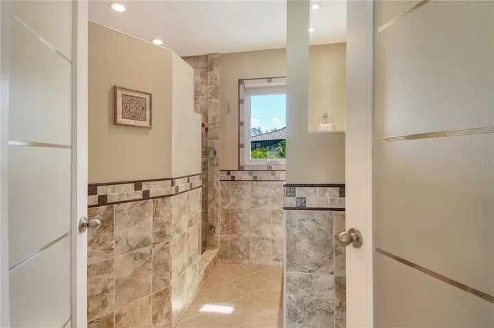 The second full bathroom showcases beautiful tile work and is in pristine condition.