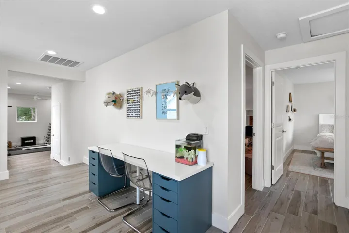 Landing at top of the stairs offers versatile flex space. Currently used as a study and a home gym area.