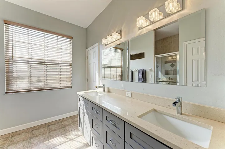 Primary bathroom with stone counters and dual vanity