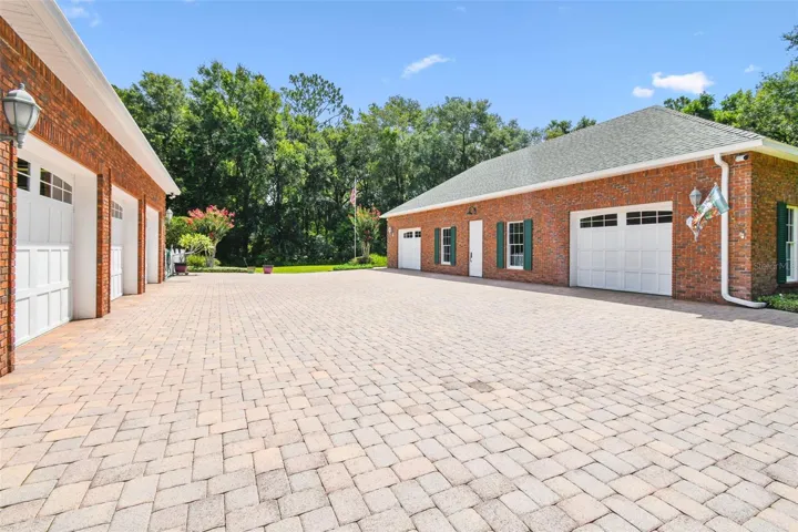 The 1,157 sq ft carriage house includes a fully equipped workshop with a 7,000 lb car lift, Snap-on workbenches, washer and dryer, laundry sink, and generous overhead storage. A custom-designed showroom offers the perfect space to showcase collectibles, automobiles, and memorabilia, featuring built-in cabinetry, display areas, and climate control for preservation and comfort.