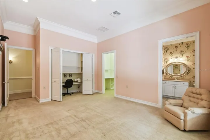 Spacious office with private half bath and direct access to the lanai. Includes a dedicated sewing area with a built-in tabletop and integrated Janome sewing machine, along with additional shelving for ample storage.