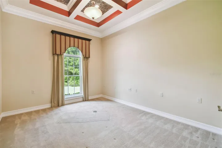 Bedroom featuring a closet and a tray ceiling accented with exposed tin inlay for a unique architectural touch.