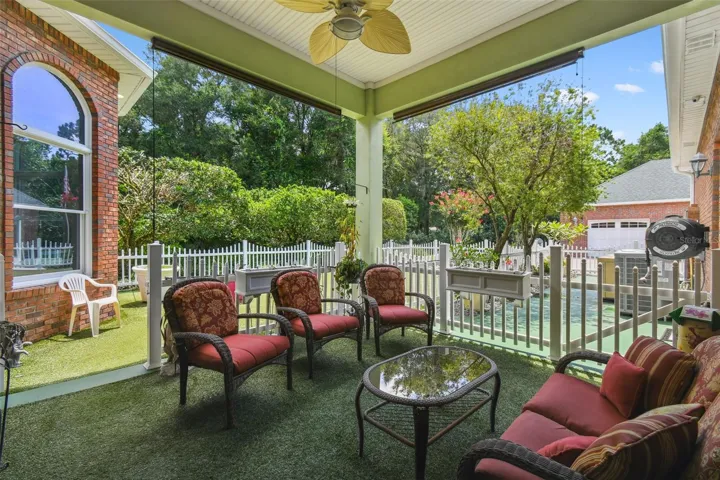 Private custom dog park featuring pet-friendly turf, secure fencing, and a ceiling fan for added comfort.